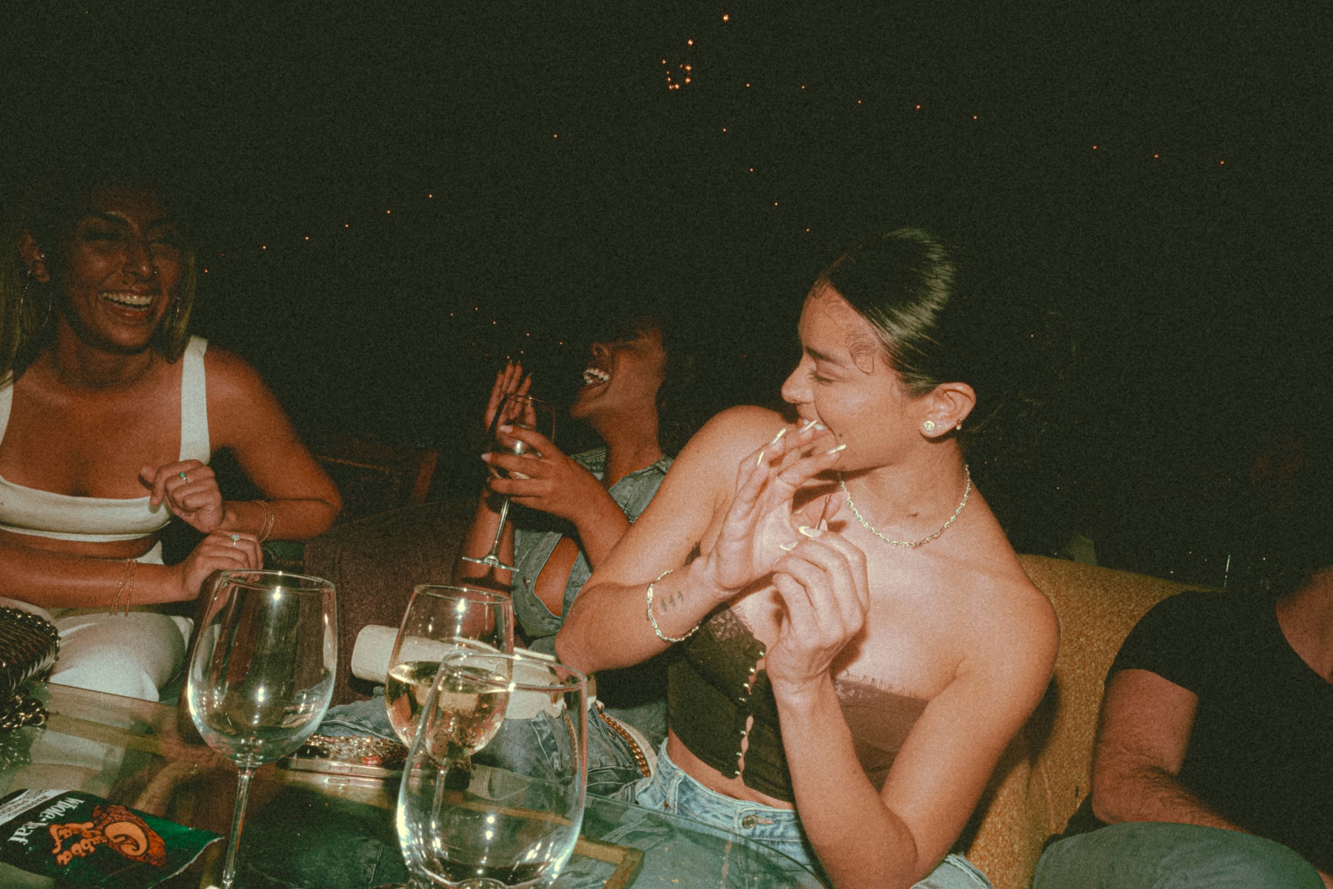Friends laughing at a candlelit dinner